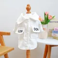 Detailaufnahme weißes Cord-Hundeshirt mit LON DON Stickerei und weißen Knöpfen am Saum - London Hemd