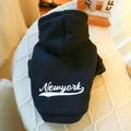 Detail of black pet hoodie featuring white Newyork print on a warm knit texture background - Black