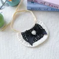 Dettaglio di bandana per cani in tweed con perla a cuore e bordo in pizzo bianco su fondo - Taglia unica / Nero