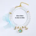 Collare per cani in perle bianche con fiocco in organza blu e ciondoli dorati - Stile Perla Campanella Fiore Blu