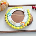 Detail of hand-knitted pet collar with music notes, rainbow patch and wood button - Musical Note Rainbow Style / Yellow