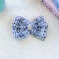 Gros plan d'une barrette nœud en tweed bleu pour animaux avec perle et strass chic - Taille unique / Bleu