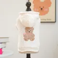 Detail der Bärenstickerei auf cremefarbenem Haustier-Hoodie mit rosa Schleifen-Akzent - XS / Teddybär (Creme)