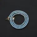 Macro detail of 4mm blue zircon tennis chain with gold plating and secure clasp closure - Gold