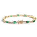 Detailed view of oval green emerald stones and round cubic zirconia on a gold tennis bracelet - Gold Green Zirconia