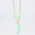 Close-up of silicone feather teething pendant with mint green and wooden beads - Green