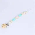 Detalle del sujetachupetes de madera con cuentas de silicona azul claro y clip metálico - Verde