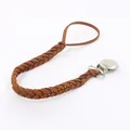 Detail eines handgeflochtenen dunkelbraunen Leder-Schnullerketthebel mit silbernem Metallclip - Braun