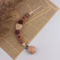 Chupetero artesanal de madera de haya y silicona con cuenta de ganchillo y girasol - Caqui