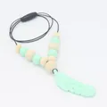 Detail of baby teething necklace with mint green feather silicone pendant and wood beads - Green