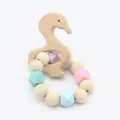 Detail of wooden swan teether and colorful silicone beads on a baby teething bracelet - Duck