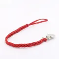 Close-up of red braided leather pacifier clip with stainless steel metal clamp - Red