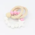 Close-up of baby teether with wooden rings, silicone beads, and white star pendant - White
