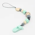 Dettaglio della catenella portaciuccio con perle di silicone menta e anello in legno - Verde