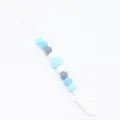 Close-up of silicone pacifier clip with multi-colored blue and grey hexagonal beads - Blue