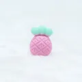 Close-up of pink and green pineapple silicone teether showing embossed grid texture - Pink