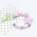 Close-up of silicone pacifier clip with star pendant and BABY letter beads - Purple