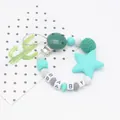 Macro shot of silicone beads and wooden clip on a pacifier chain with BABY letter beads - Dark Green