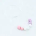 Detailed macro view of macaron silicone teething beads with safety breakaway clasp - Pink