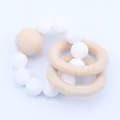 Close-up of silicone beads and natural wooden rings on a baby teething bracelet - White