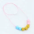 Detail of colorful geometric silicone teething beads with a secure white plastic clasp - Blue
