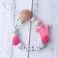 Silicone and wood baby pacifier clip with pink crown and BABY letter beads on white wood - Rose Red