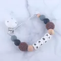 Detailaufnahme von Silikon Schnullerkette mit Holzperlen und BABY Buchstabenperlen - Kaffeebraun