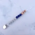 Detail of baby pacifier clip with marble silicone beads, wood accents, and metal clasp - Royal Blue