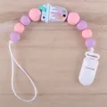 Detail of macaron silicone pacifier clip with purple ice cream charm on wood background - Ice Cream-Purple