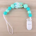 Detail view of silicone pacifier clip with mint ice cream bead on wooden background - Ice Cream - Green
