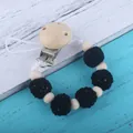 Sujeta chupete con cuentas de madera natural y cuentas de ganchillo negras sobre madera - Negro