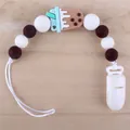 Close-up of silicone baby pacifier clip with brown beads and bubble tea charm on wood background - Ice Cream - Brown