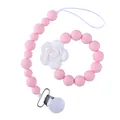 Gros plan sur l'attache-tétine en silicone rose avec une fleur de camélia blanche - Attache-tétine Rose avec Fleur Blanche (C008) / Rose