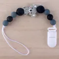 Detailaufnahme der Silikon-Schnullerkette mit grauem Koala und Perlen auf Holzdekor - Koala - Grau
