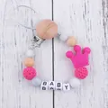 Detail of baby pacifier clip with wood clasp, silicone beads, and pink crown pendant - Rose Red (New)