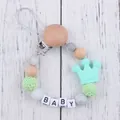 Detail of baby pacifier clip with natural wood beads, mint crown, and BABY letter beads - Mint Green (New)
