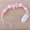 Rosa Silikon-Schnullerkette mit Waschbär-Perle auf feinem Holzmaserung-Hintergrund - Waschbär - Rosa