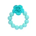 Detail of turquoise silicone baby teether showing rose charm and soft round beads texture - Green