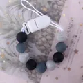 Dettaglio catenella portaciuccio in perline di silicone grigio con clip di plastica - Gradiente Nero Grigio