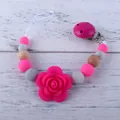 Detailansicht der Silikonperlen und Holzperlen an der Schnullerkette mit Rose - Rosarot