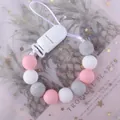 Catenella portaciuccio in silicone con perle rosa e grigie su sfondo di piante tropicali - sfumatura rosa e bianca