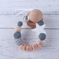 Detalle de sujetachupetes con estrellas de silicona, madera y letras BABY grabadas - Gris