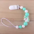 Detail of silicone pacifier clip with mint green beads and a cartoon unicorn charm - Green Unicorn