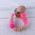 Chupetero de silicona rosa y madera con cuentas de letras sobre fondo de madera - Rosa rojo