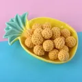 Macro detail of 16mm yellow crochet cotton balls for DIY jewelry accessories in a tray - Bright Yellow