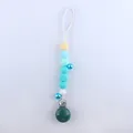 Detail of baby pacifier clip with colorful silicone beads and metal bells on grey background - Lake Blue