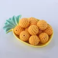 Primer plano de cuentas de ganchillo naranjas en un plato de piña para joyería artesanal - 20mm / Amarillo