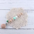 Detail of wooden beech and silicone pacifier clip with star beads and mint green bell - Green Pacifier Chain