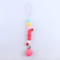 Macro view of colorful silicone beads and metal pacifier clip for baby teething safety - Red