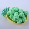 Detail of 20mm mint green crochet covered beads arranged in a yellow pineapple tray - Green